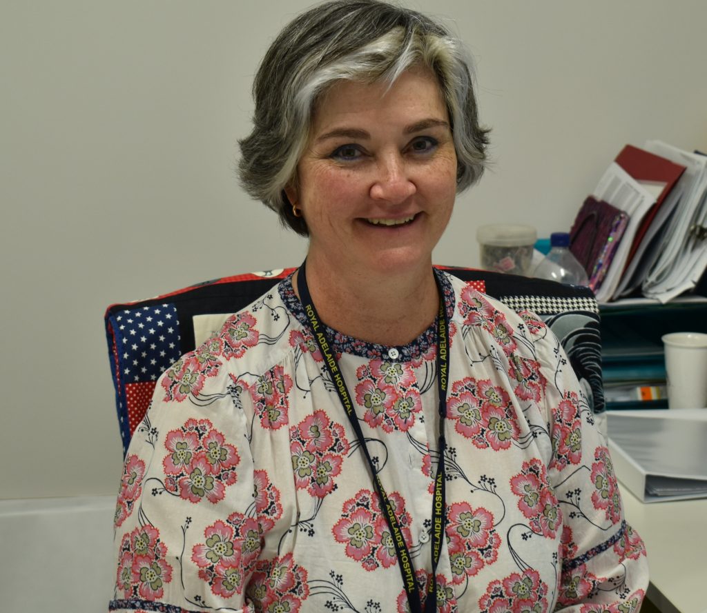 Woman smiling at camera while sitting at desk