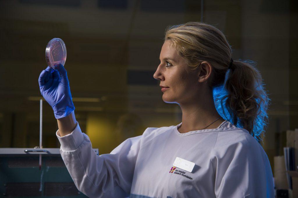 Female microbiologist looking at petri dish